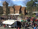 Blick auf Pauluskirche mit den KAB Verkaufständen und den davor herfahrenden Karnevalsumzug
